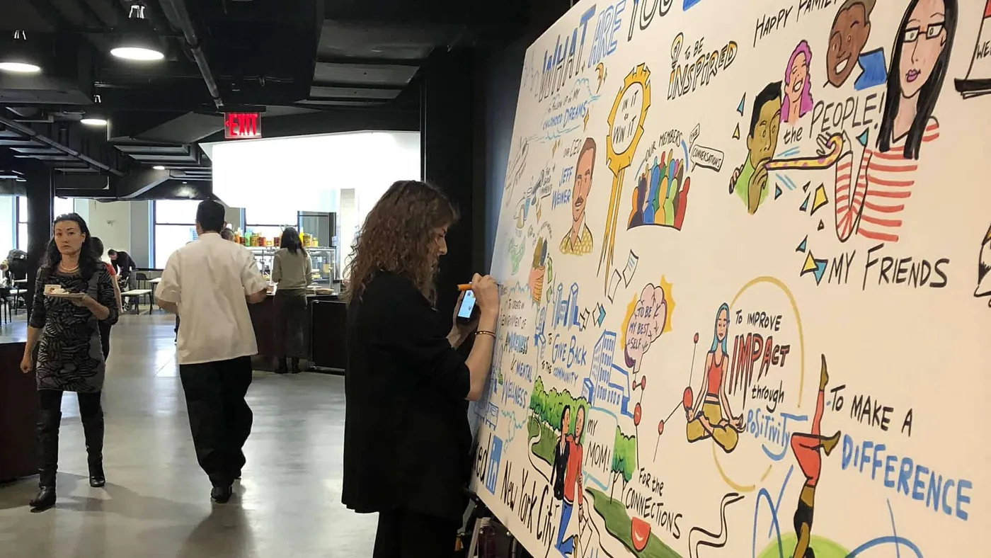 An ImageThink artist draws the LinkedIn board in the New York office cafeteria while employees walk past.