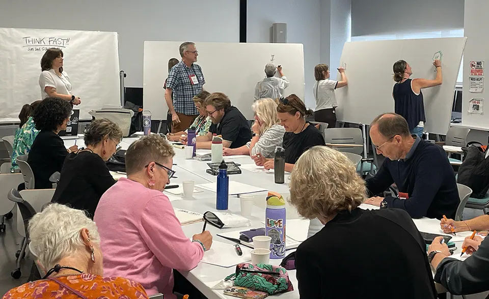 A group of people engaging in visual graphics at the 2024 Annual Conference.