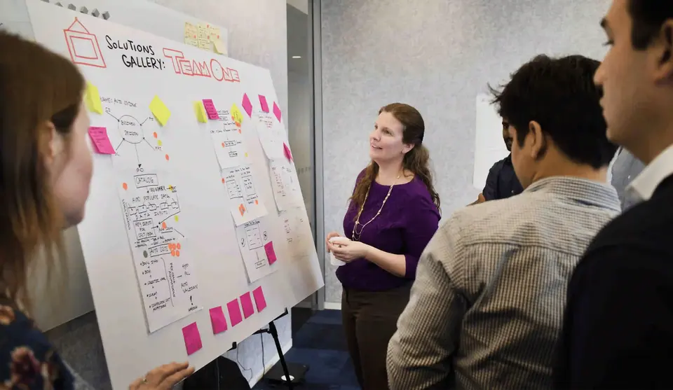 ImageThink facilitator reviewing graphic recording chart with product development team.