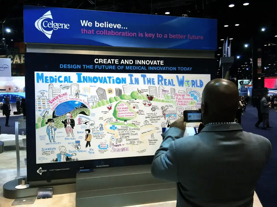 Attendee viewing a large-scale graphic recording at a medical innovation industry conference.