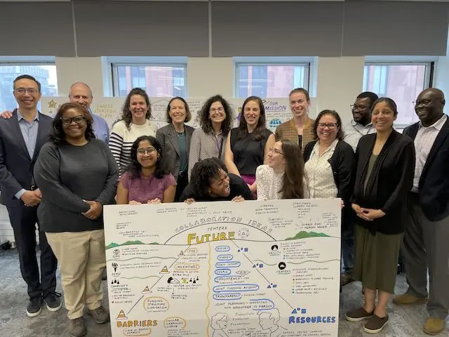 NYU GPH poses with a board that captures the future state of their team and centers.