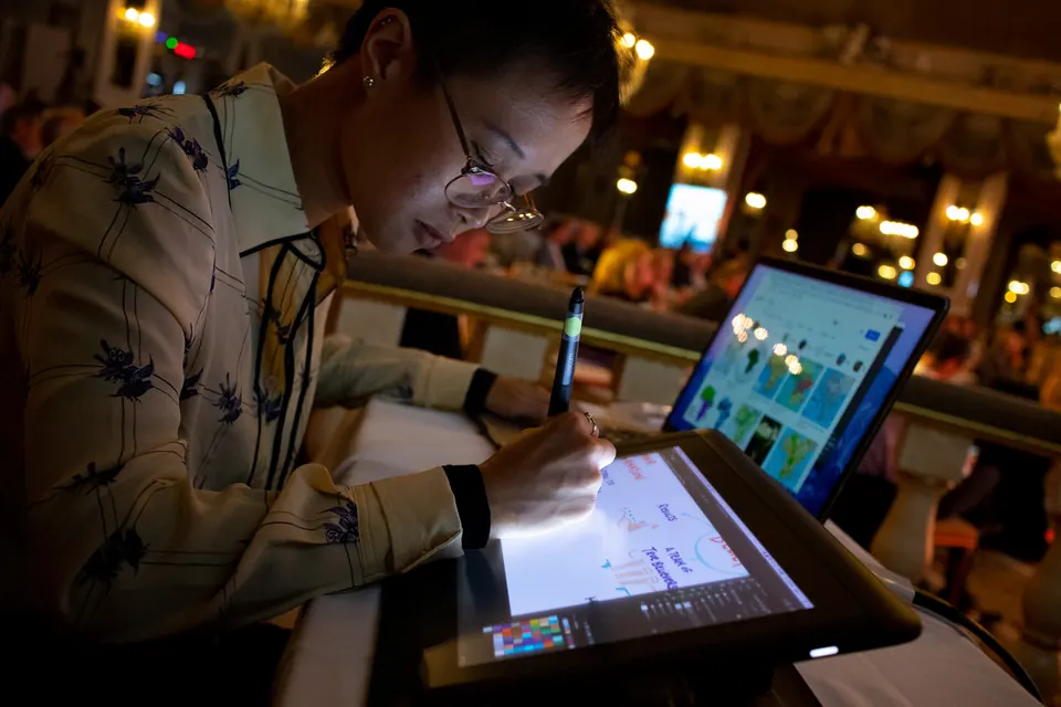 An ImageThink graphic recorder drawing digitally on a tablet live at an event